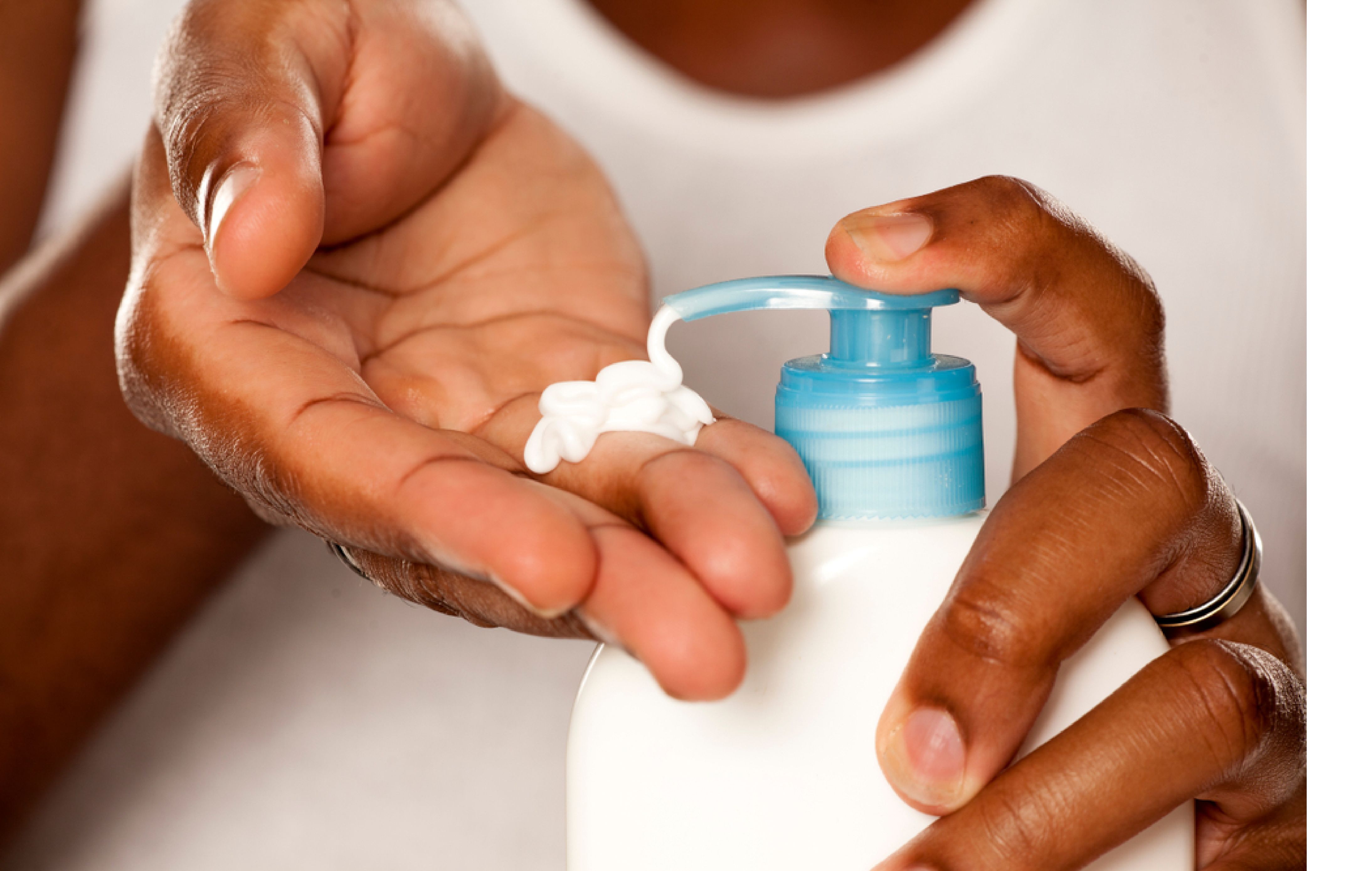 Hands pumping out lotion from a blue lotion pump.